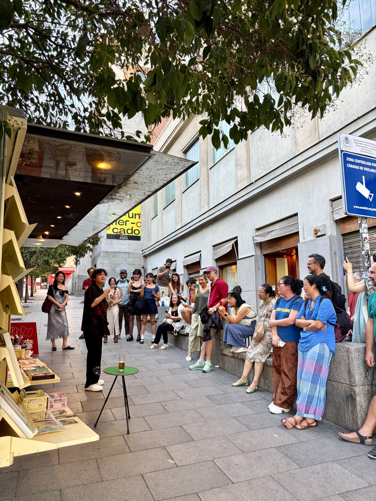 Intérprete de performance leyendo ante el público junto al kiosco