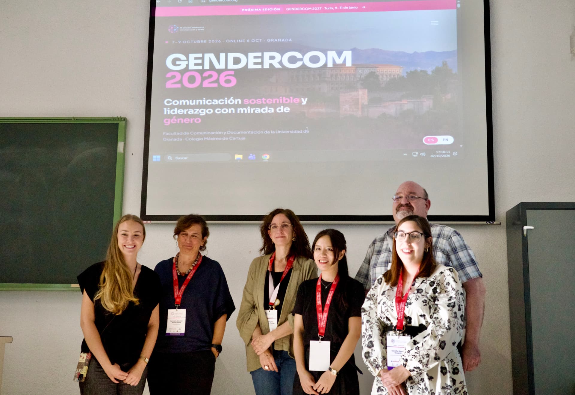 Ponentes de la mesa posando bajo la pantalla de GENDERCOM 2026
