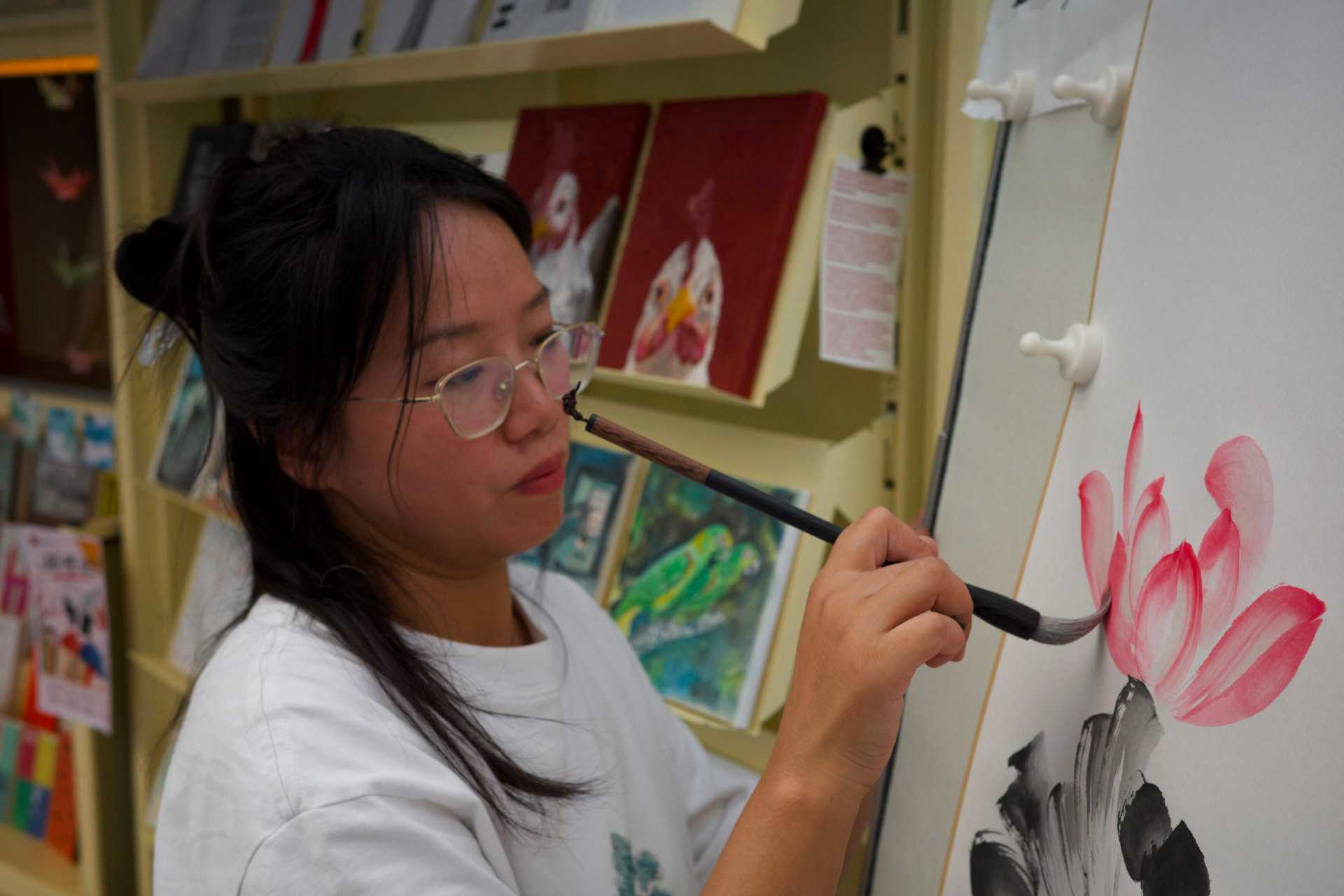 Artista pintando una flor de loto con tinta china